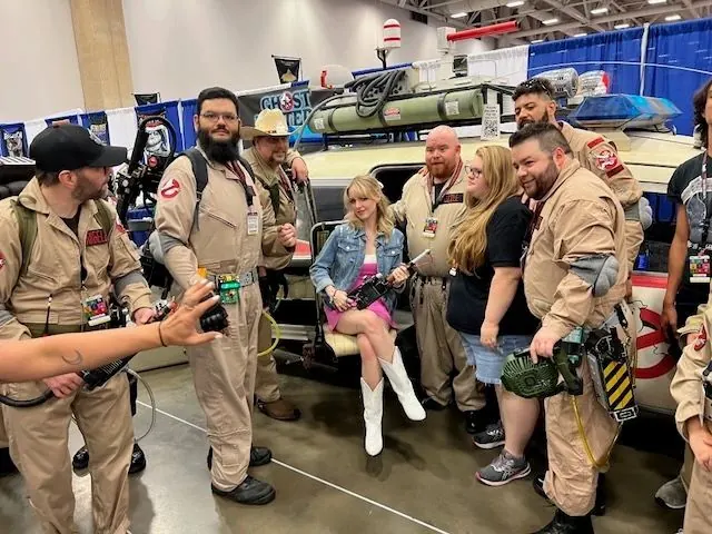 Fans and Ghostbusters cosplayers with the finished gunner seat at FanExpo Dallas 2024